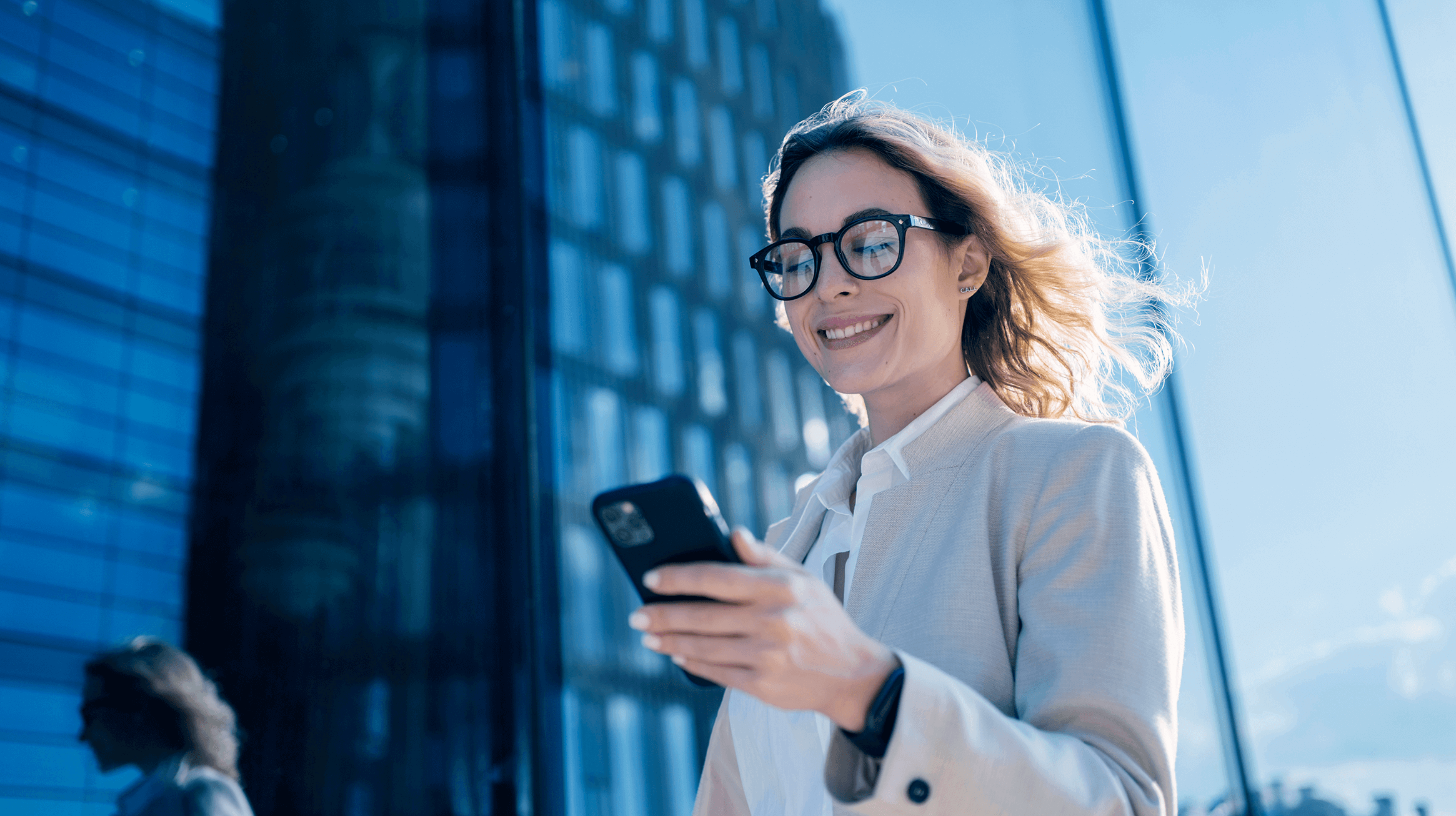 Mulher em primeiro plano olhando o celular